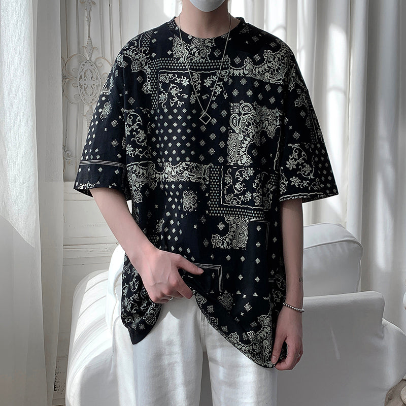 Black loose t-shirt with an all-over paisley bandana pattern, worn by a model, front view