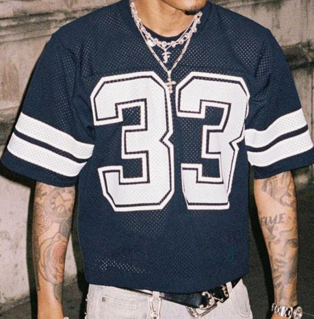 Navy mesh sports t-shirt with a large number 33 and sleeve stripes, worn by a model, front view
