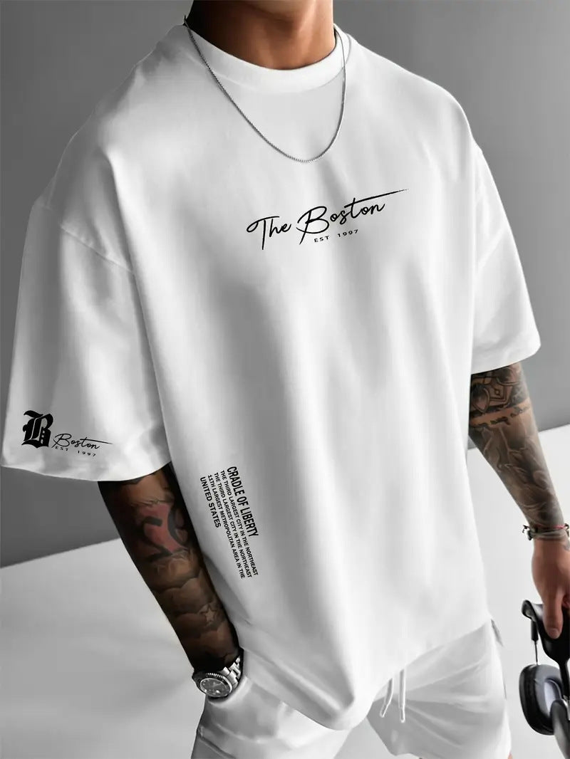 White oversized t-shirt with a script print on the chest and a small sleeve emblem, worn by a model, front view