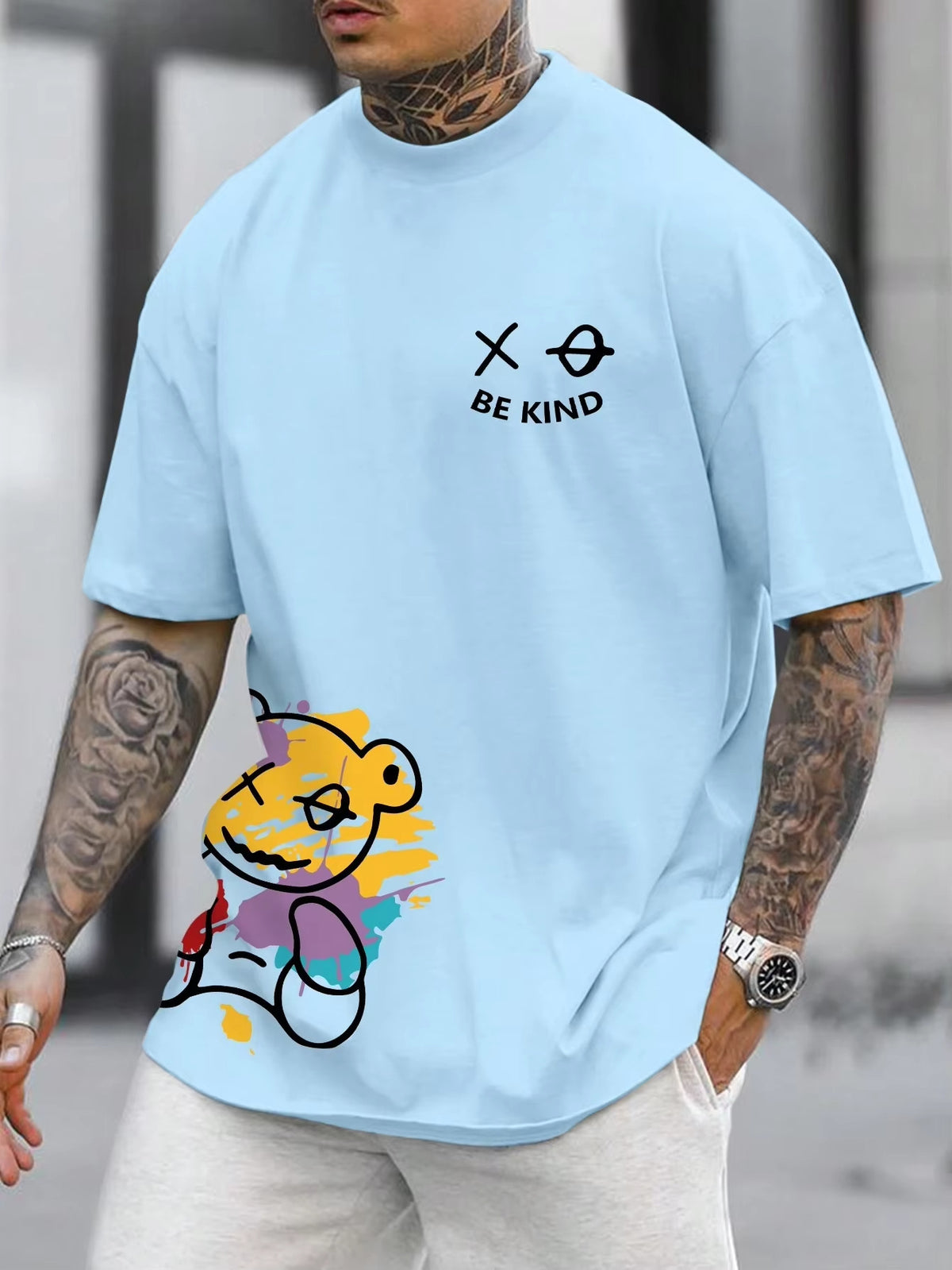 Sky Blue t-shirt with a cartoon bear graphic at the hem and small text on the chest, worn by a model, front view