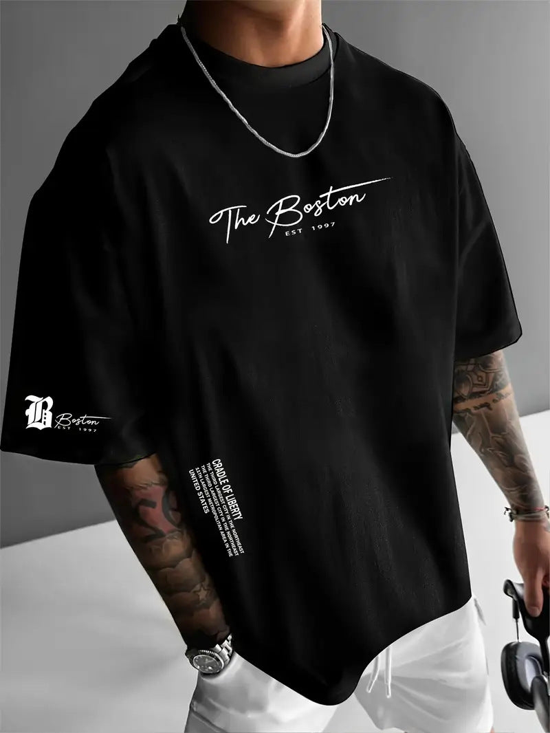 Black oversized t-shirt with a script print on the chest and a small sleeve emblem, worn by a model, front view