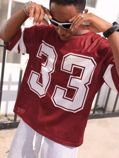 Burgundy mesh sports t-shirt with a large number 33 and sleeve stripes, worn by a model, front view