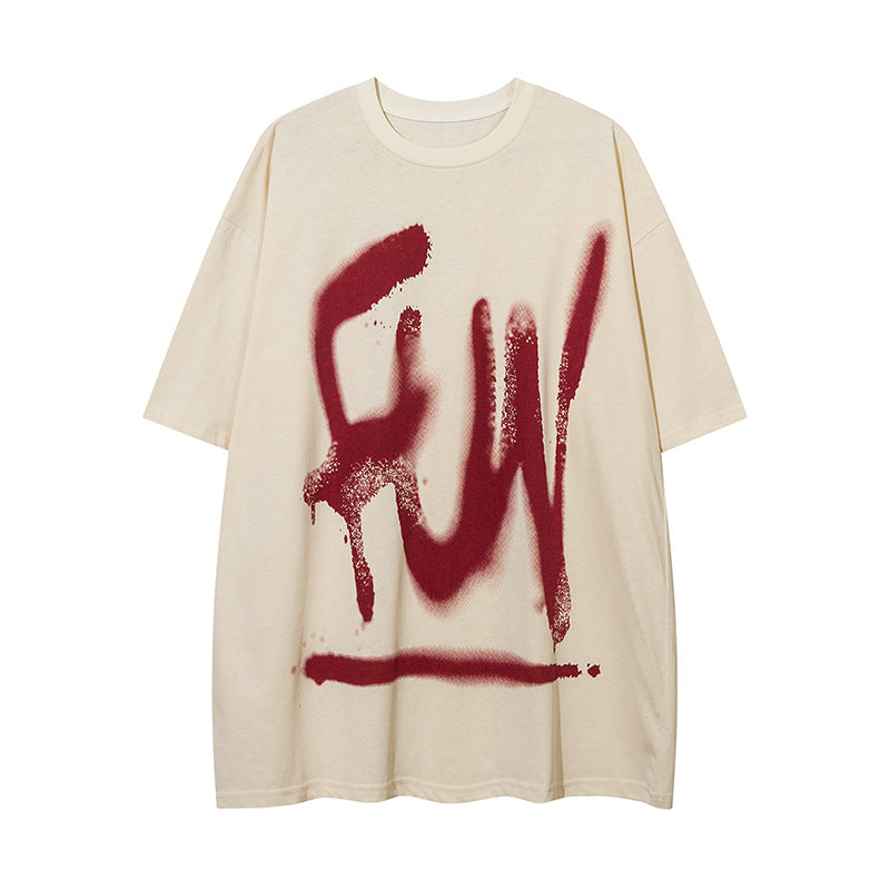 Cream t-shirt with a large spray graffiti print on the chest, flat lay, front view